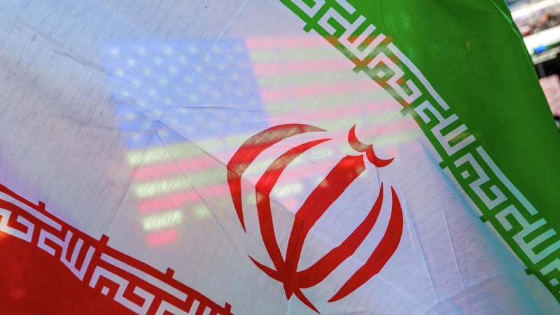 Флаг США виден сквозь флаг Ирана